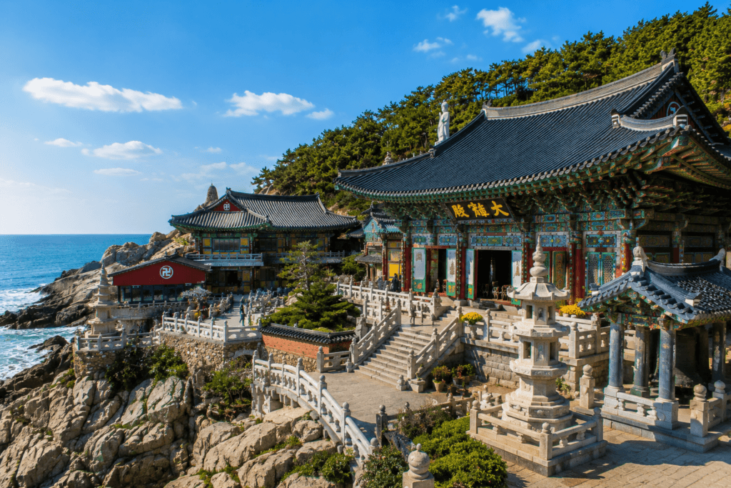 Main temple buildings of Haedong Yonggungsa overlooking the sea with colorful Korean Buddhist architecture and rocky coastline