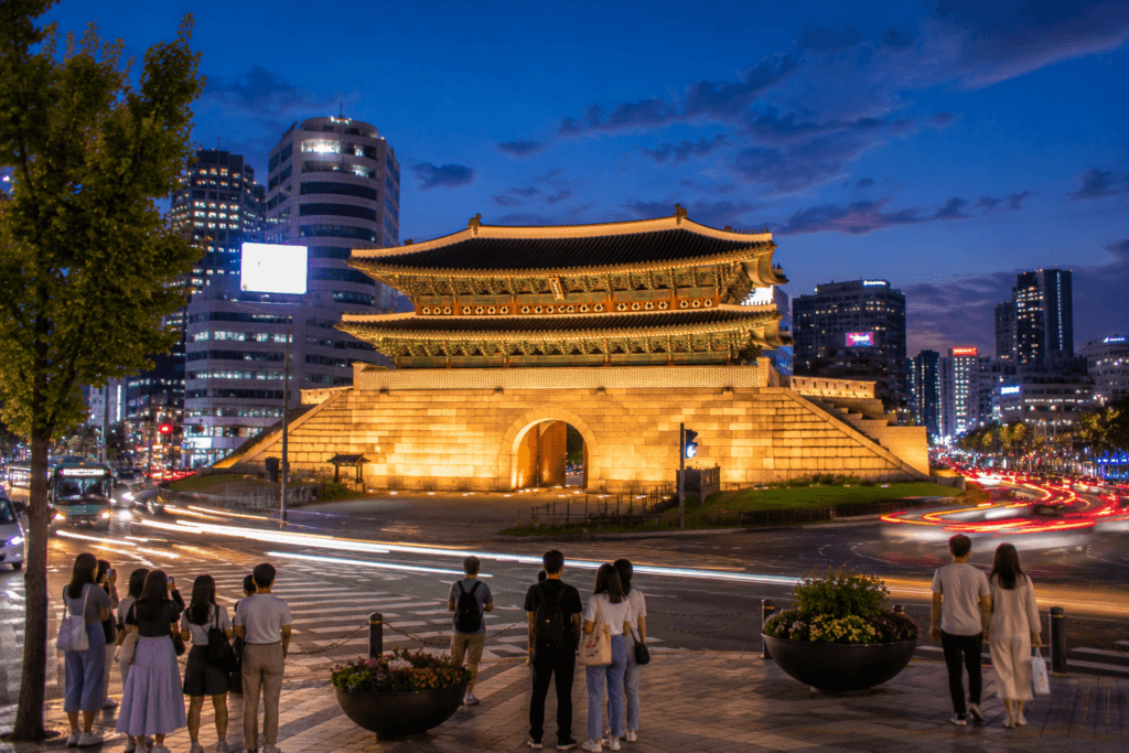 Heunginjimun Gate in Dongdaemun at twilight with modern Seoul buildings nearby