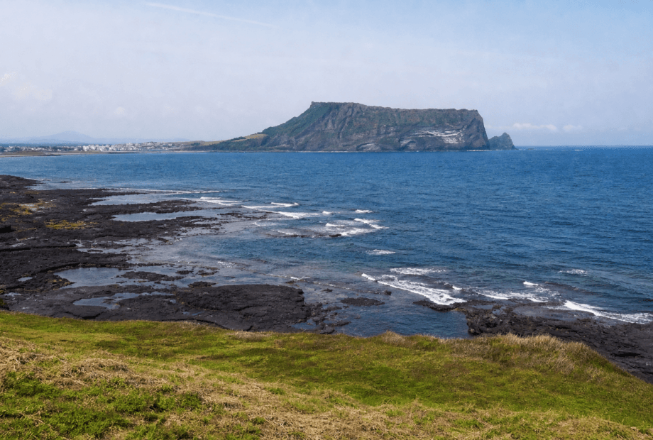Natural coastal view of Seongsan Ilchulbong across the volcanic shoreline in Jeju