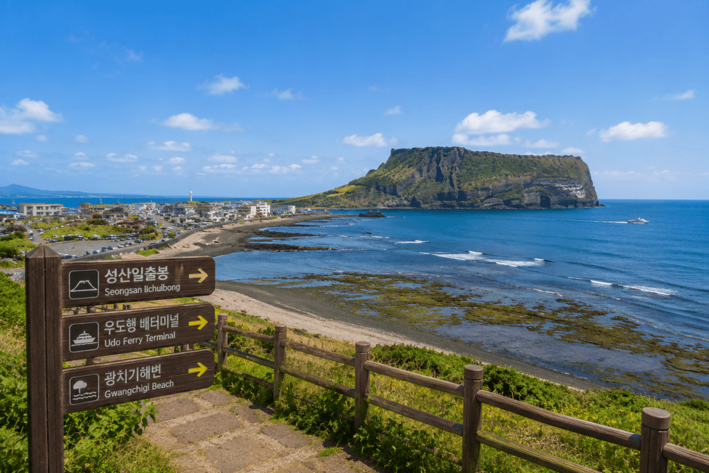 Coastal view near Seongsan Ilchulbong with signs pointing to Udo Island and nearby attractions