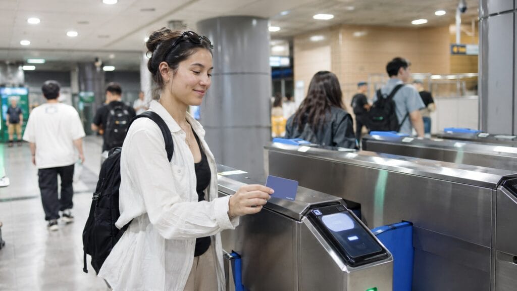 Tourist tapping a transit card at a Seoul subway gate