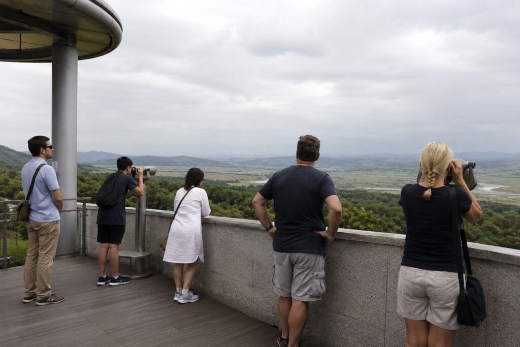Visitors looking across the DMZ landscape from an observation deck near Seoul