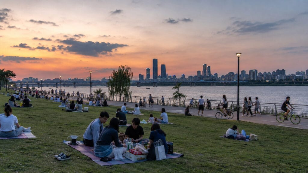 People having picnics and cycling at Hangang Park during sunset