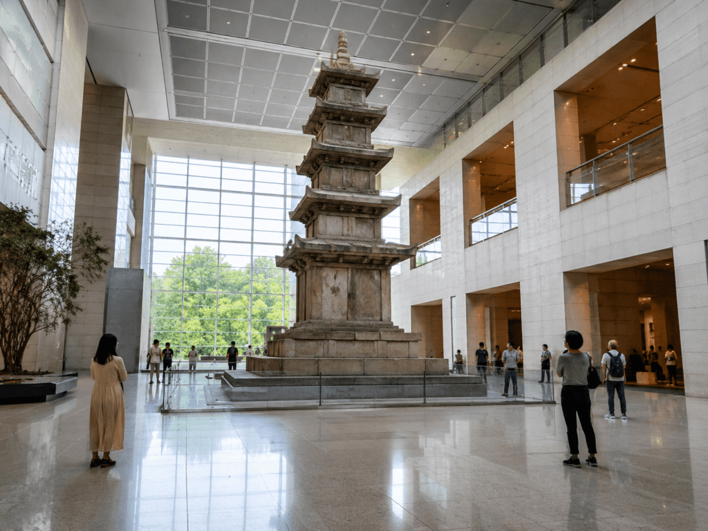 National Museum of Korea main hall with tall stone pagoda, high ceilings, visitors and bright indoor museum space