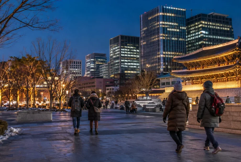 Travelers walking through central Seoul during a clear December evening