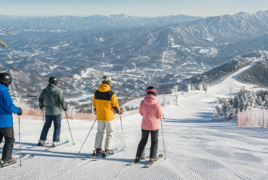 Skiers overlooking snowy mountain slopes at a Korean ski resort