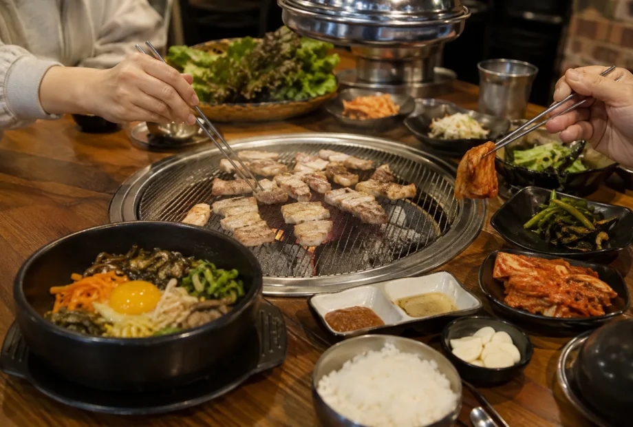 Diners sharing Korean barbecue, bibimbap and banchan at a restaurant