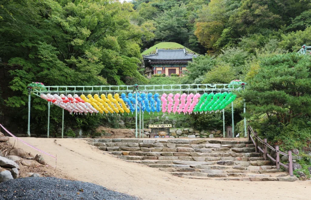 Stone steps, hanging lanterns and the wooded exterior at Seokguram, photographed in October 2022