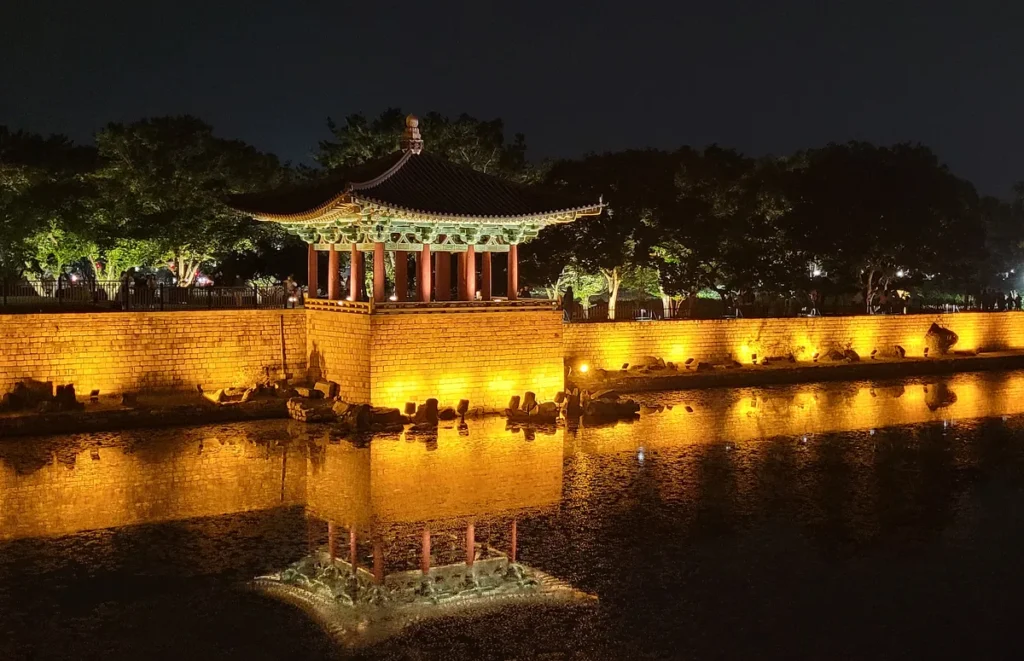Illuminated pavilion, stone embankment and reflections at Donggung Palace and Wolji Pond at night