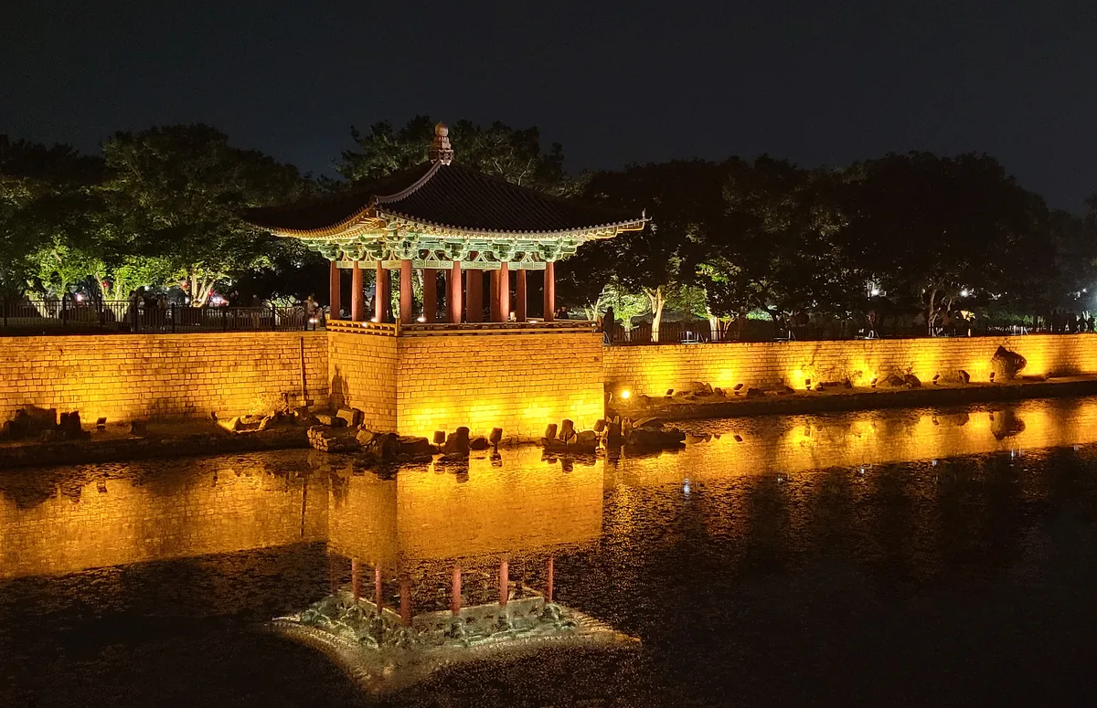 Illuminated pavilion, stone embankment and reflections at Donggung Palace and Wolji Pond at night